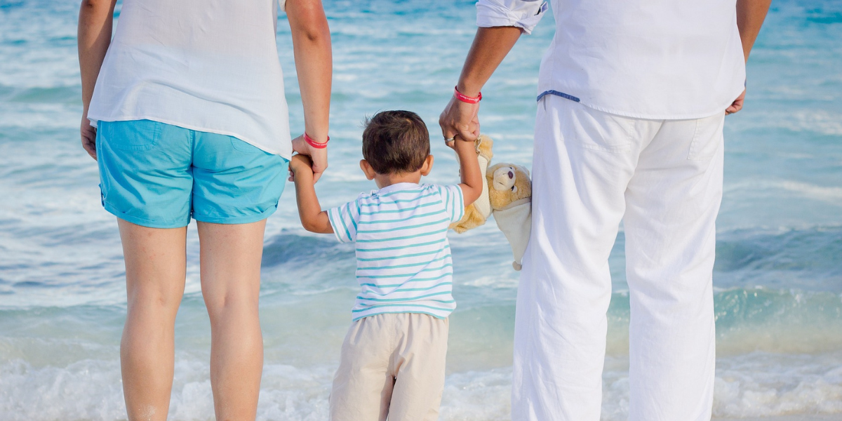 Family reunited after obtaining the Refugee Family Support Resident Visa, smiling and embracing at an airport.